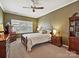 Cozy bedroom with carpet, a ceiling fan, warm lighting, and ample natural light from large windows at 2516 Middlebridge Ln, Charlotte, NC 28270
