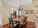 Dining area featuring hardwood floors, a chandelier, and views into the kitchen at 2516 Middlebridge Ln, Charlotte, NC 28270