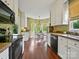 Open kitchen area with light green walls, stainless appliances, and hardwood floors at 2516 Middlebridge Ln, Charlotte, NC 28270