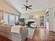 Bright living room featuring a fireplace, built-in shelving, and a ceiling fan at 2516 Middlebridge Ln, Charlotte, NC 28270