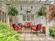 Back patio with shade cover, red seating and surrounding plants at 2516 Middlebridge Ln, Charlotte, NC 28270