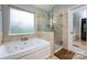 Modern bathroom featuring a luxurious tub and shower combo with stone-look tile surround at 3505 Mayspring Pl, Charlotte, NC 28269