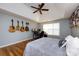 Spacious bedroom with hardwood floors, guitars, a ceiling fan, and a dedicated workspace area at 3505 Mayspring Pl, Charlotte, NC 28269