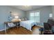 Cozy bedroom with hardwood floors, desk, and a large window offering natural light at 3505 Mayspring Pl, Charlotte, NC 28269