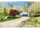 View of house with long driveway, two car garage and landscaped yard with trees at 3505 Mayspring Pl, Charlotte, NC 28269