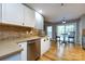 Modern kitchen with stainless steel dishwasher, light countertops, and bar stools at 3505 Mayspring Pl, Charlotte, NC 28269