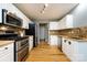 Updated kitchen features stainless steel appliances, modern lighting, and light wood floors at 3505 Mayspring Pl, Charlotte, NC 28269