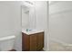 Bathroom featuring a vanity, mirror, and a toilet with a wooden seat near storage at 3944 Hemingway Nw Dr, Hickory, NC 28601