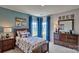 Cozy carpeted bedroom featuring two windows with blue curtains, a bed, and a dresser at 4025 Cramer Estates Ct, Gastonia, NC 28056