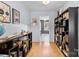 Hallway with hardwood floors, neutral paint and decorative shelving with view of study area at 4607 Hedgemore Dr # D, Charlotte, NC 28209