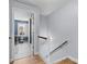 Hallway at top of staircase leading to home office space, featuring light blue walls and wood railing at 4607 Hedgemore Dr # D, Charlotte, NC 28209