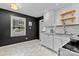 Updated kitchen with white cabinets, black walls, granite counters, and hexagonal tile flooring at 4607 Hedgemore Dr # D, Charlotte, NC 28209