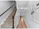 Staircase featuring carpeted steps, a wood handrail, and leading to an open hallway with hardwood floors at 4607 Hedgemore Dr # D, Charlotte, NC 28209
