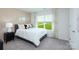 Bedroom with a bed dressed in white, a black nightstand, and a window with lush greenery at 4610 Harris Elliot Rd, Lincolnton, NC 28092