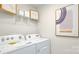 A bright laundry room features white appliances, shelving, and artwork for a clean and organized space at 4610 Harris Elliot Rd, Lincolnton, NC 28092