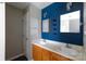 Bathroom featuring double sinks, wood cabinets, and blue accent wall at 5015 Drake Pond Ln, Rock Hill, SC 29732