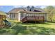 Expansive backyard featuring a deck, lush green lawn, and playful slide at 5108 Boardwalk Ct, Dallas, NC 28034
