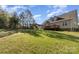Large backyard with mature trees, wooden deck, play set and lush green grass at 5108 Boardwalk Ct, Dallas, NC 28034