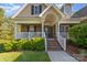 Inviting entrance with a charming porch, brick stairs, white railings and lush landscaping at 5108 Boardwalk Ct, Dallas, NC 28034