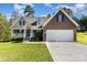Charming brick and siding home featuring a two-car garage and inviting front porch with a manicured lawn at 5108 Boardwalk Ct, Dallas, NC 28034