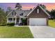 Charming brick and siding home featuring a two-car garage and inviting front porch with a manicured lawn at 5108 Boardwalk Ct, Dallas, NC 28034