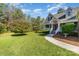 Beautifully landscaped front yard featuring lush green grass, mature trees, and a charming walkway to the front door at 5108 Boardwalk Ct, Dallas, NC 28034