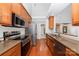 Galley kitchen with stainless steel appliances, granite countertops, and wood cabinets at 5108 Boardwalk Ct, Dallas, NC 28034