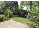 Secluded backyard featuring a brick patio, a lush lawn, mature trees, and landscaping at 6910 Green Turtle Dr, Charlotte, NC 28210