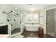 Well-appointed bathroom featuring a standalone tub, and a separate walk-in shower with a neutral color palette at 6910 Green Turtle Dr, Charlotte, NC 28210