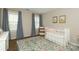Bedroom featuring a crib, large windows, neutral walls, and colorful floral rug at 6910 Green Turtle Dr, Charlotte, NC 28210