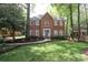 Charming two-story red brick home featuring a lush green lawn and mature trees at 6910 Green Turtle Dr, Charlotte, NC 28210