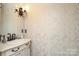 Chic powder room featuring custom wall detail, vanity with sink and classic fixtures at 6910 Green Turtle Dr, Charlotte, NC 28210