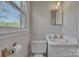 A charming bathroom features patterned wallpaper, a modern mirror, and a large window overlooking the outside at 70 Liberty Church Rd, Taylorsville, NC 28681