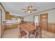 A dining area has a vintage ceiling fan and is adjacent to a kitchen with wood cabinets at 70 Liberty Church Rd, Taylorsville, NC 28681
