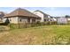 Spacious backyard with a black fence, featuring a patio and mature trees at 7633 Tanglewood Way, Denver, NC 28037