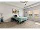 Bright bedroom featuring a tray ceiling, modern ceiling fan, full-length mirror, and abundant natural light at 7633 Tanglewood Way, Denver, NC 28037