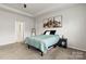 Spacious bedroom features a tray ceiling, plush carpeting, mountain art, and neutral color palette at 7633 Tanglewood Way, Denver, NC 28037