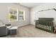 Comfortable Bedroom with modern crib, chair, ottoman, and natural light at 7633 Tanglewood Way, Denver, NC 28037