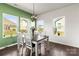 Bright dining area with a view featuring hardwood floors, natural light, and modern light fixture at 7633 Tanglewood Way, Denver, NC 28037