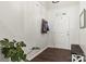 Bright entryway featuring a monstera plant, coat rack, and bench; dark wood flooring adds richness at 7633 Tanglewood Way, Denver, NC 28037