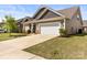 View of home's exterior with a two-car garage and well-maintained lawn at 7633 Tanglewood Way, Denver, NC 28037