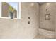Elegant tiled shower with seating and niche and window, providing ample natural light at 7633 Tanglewood Way, Denver, NC 28037