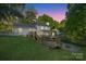 Expansive backyard with a multi-tiered deck, a fire pit and a lush green lawn at 8025 Cliffside Dr, Charlotte, NC 28270