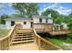 Exterior view of the home's backyard featuring a wooden deck and staircase, perfect for outdoor entertaining at 8025 Cliffside Dr, Charlotte, NC 28270