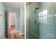 Updated shower features green tile, and gold fixtures in a renovated bathroom at 8025 Cliffside Dr, Charlotte, NC 28270
