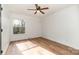 Bedroom with light, hardwood floors, ceiling fan, and a large window at 8025 Cliffside Dr, Charlotte, NC 28270