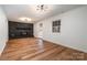 Spacious living room featuring hardwood floors, updated lighting fixtures and a cozy, black brick fireplace at 8025 Cliffside Dr, Charlotte, NC 28270