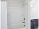 Bright white bathroom with tub and shower combination, and a dark-toned vanity with sink at 8715 Gladden Hill Ln, Fort Mill, SC 29715