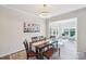 Bright dining room with decorative chandelier, wooden table and chairs, and view to open space with natural light at 8715 Gladden Hill Ln, Fort Mill, SC 29715