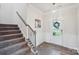 Welcoming foyer featuring a staircase, wood floors, and a decorative light fixture at 8715 Gladden Hill Ln, Fort Mill, SC 29715